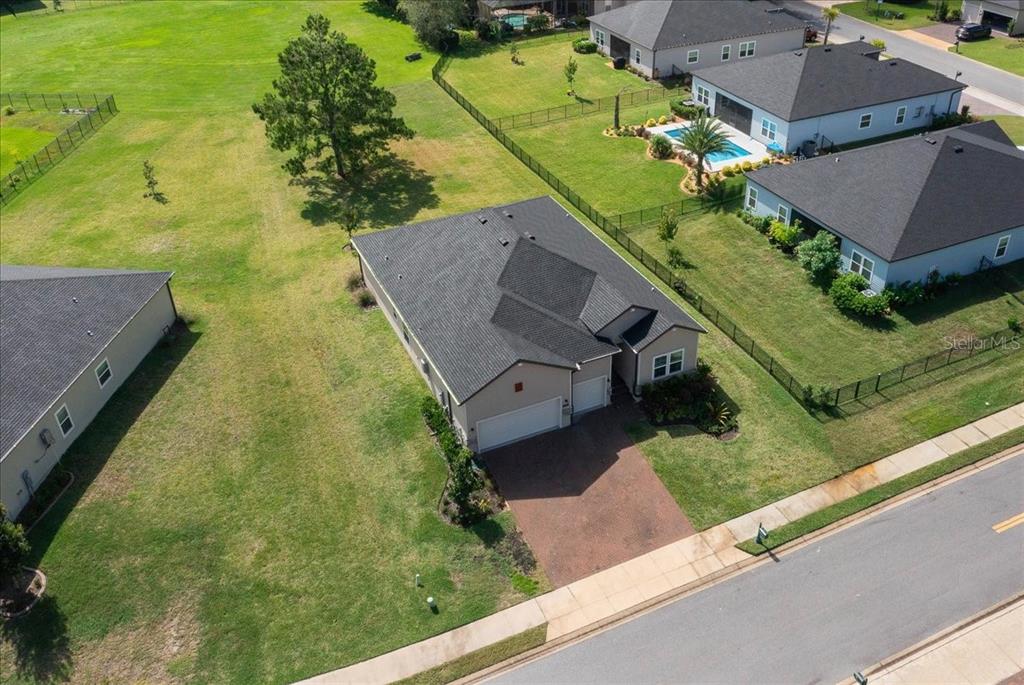 An aerial view shows a single-story house with a dark roof and a paved driveway — 1130 SE 42ND ROAD, OCALA, FL