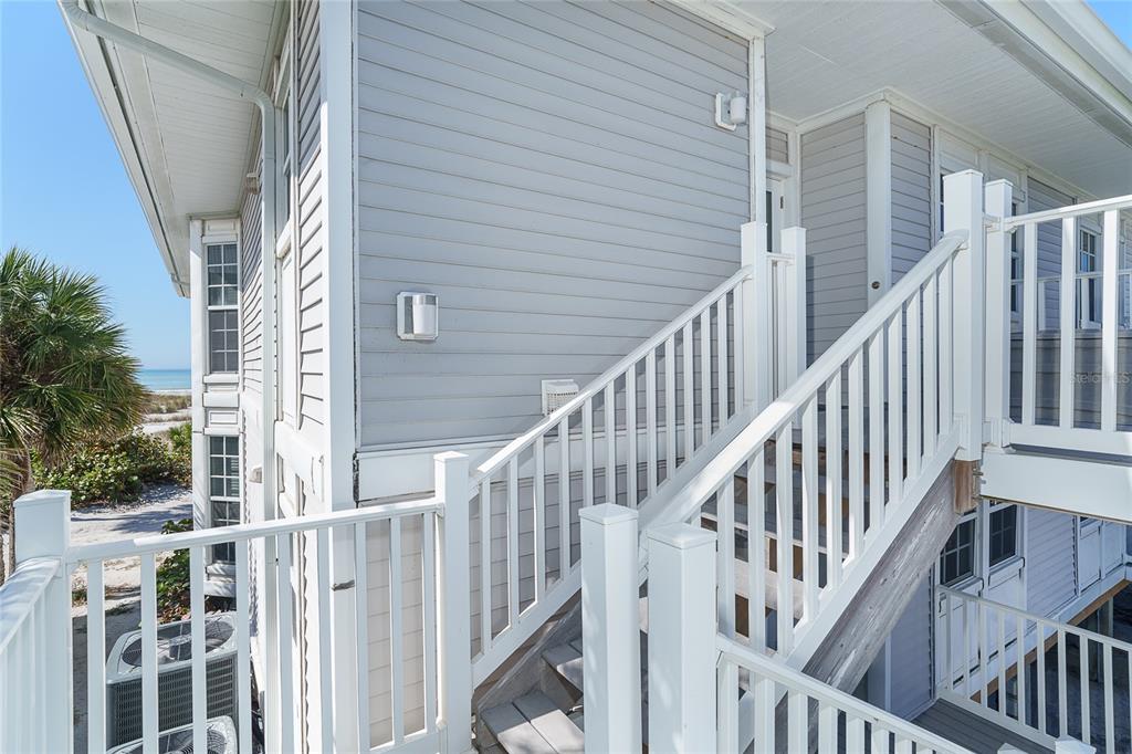 An exterior view of a beach house with white railings and light gray siding — 7494 PALM ISLAND DRIVE UNIT 2224, PLACIDA, FL