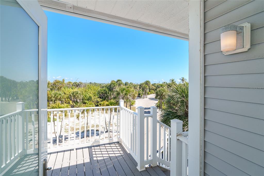 A view from a balcony looking out over a sandy path and tropical vegetation — 7494 PALM ISLAND DRIVE UNIT 2224, PLACIDA, FL
