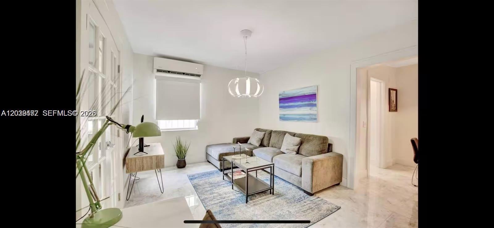 A living room features a gray sectional sofa, a glass coffee table, and a blue rug — 174 NE 47th St # 202, Miami FL 33137, MIAMI, FL
