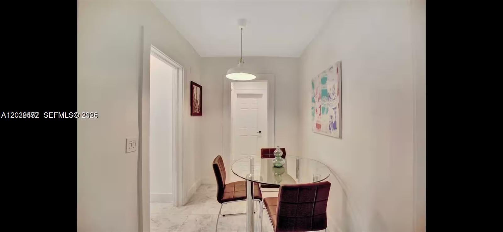 A dining area features a glass-topped table, two chairs, and a pendant light fixture — 174 NE 47th St # 202, Miami FL 33137, MIAMI, FL