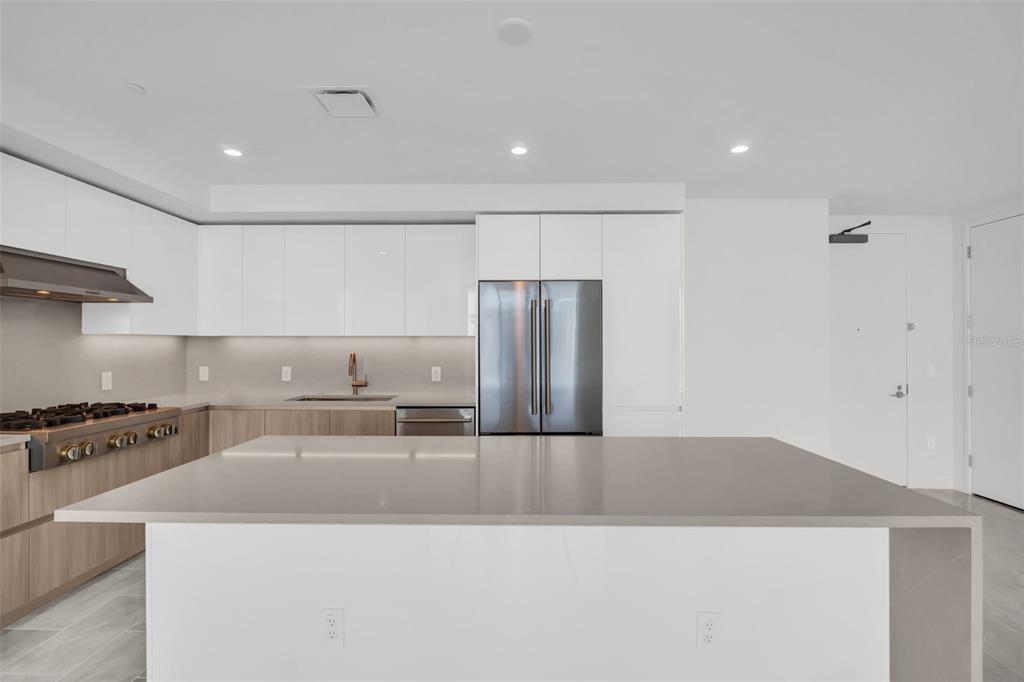 A modern kitchen features white cabinetry, a large gray island, and stainless steel appliances — 400 CENTRAL AVENUE UNIT 2605, ST PETERSBURG, FL