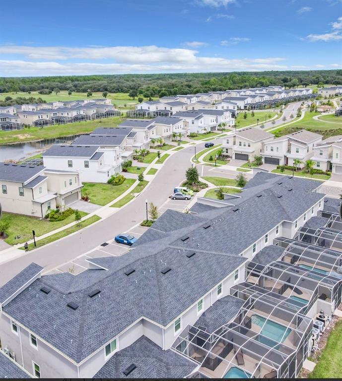 An aerial view shows a residential neighborhood with multi-family homes, screened-in pools, and streets — 452 OCEAN COURSE AVENUE, DAVENPORT, FL