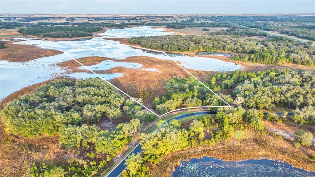 An aerial view shows a plot of land outlined in white surrounded by wetlands — 3106 BRIGHT LAKE CIRCLE, GROVELAND, FL