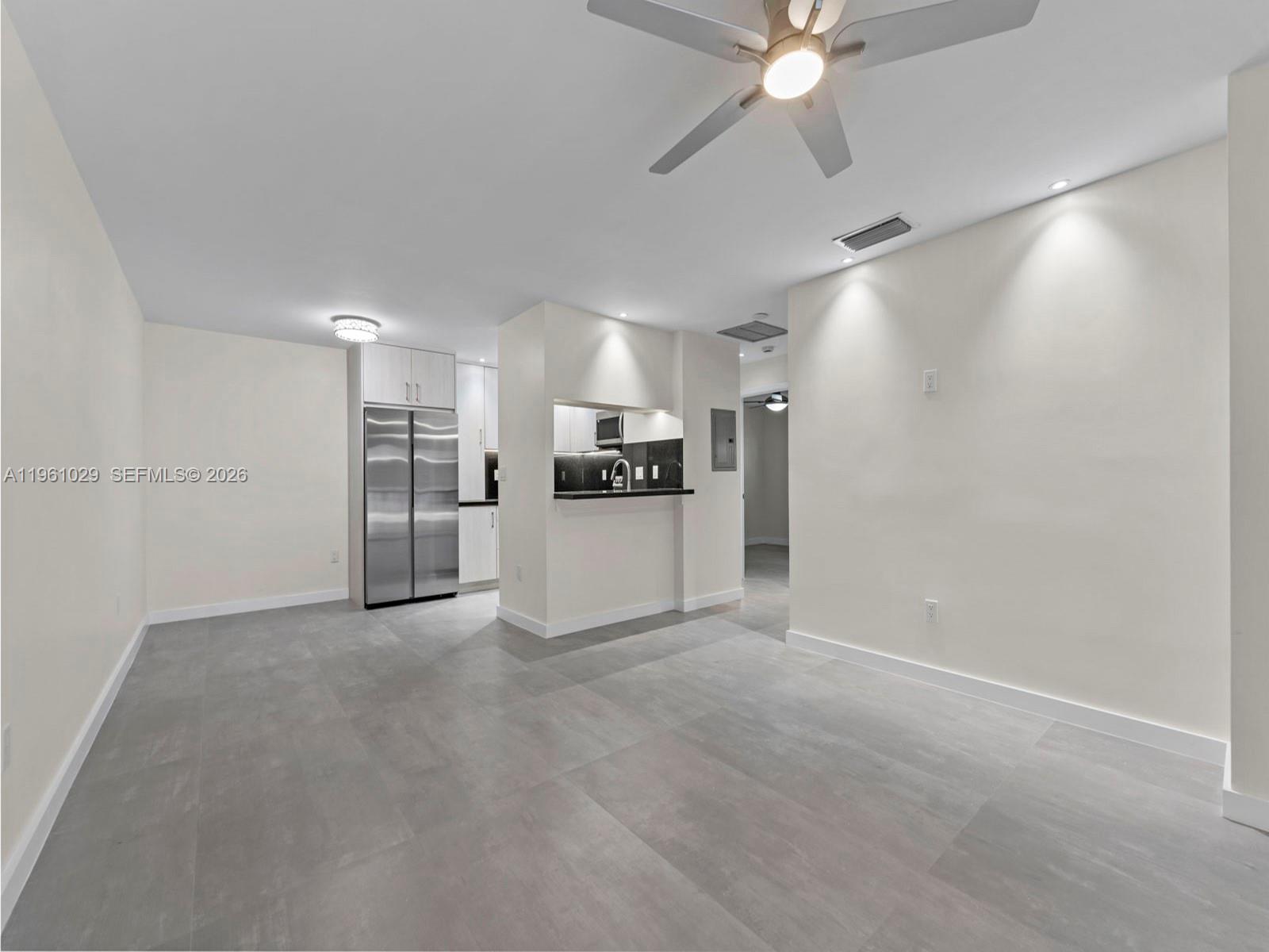 An open-concept living area features gray tile flooring, a ceiling fan, and a kitchen pass-through — 15639 SW 73rd Cir Ter # 4, Miami FL 33193, MIAMI, FL