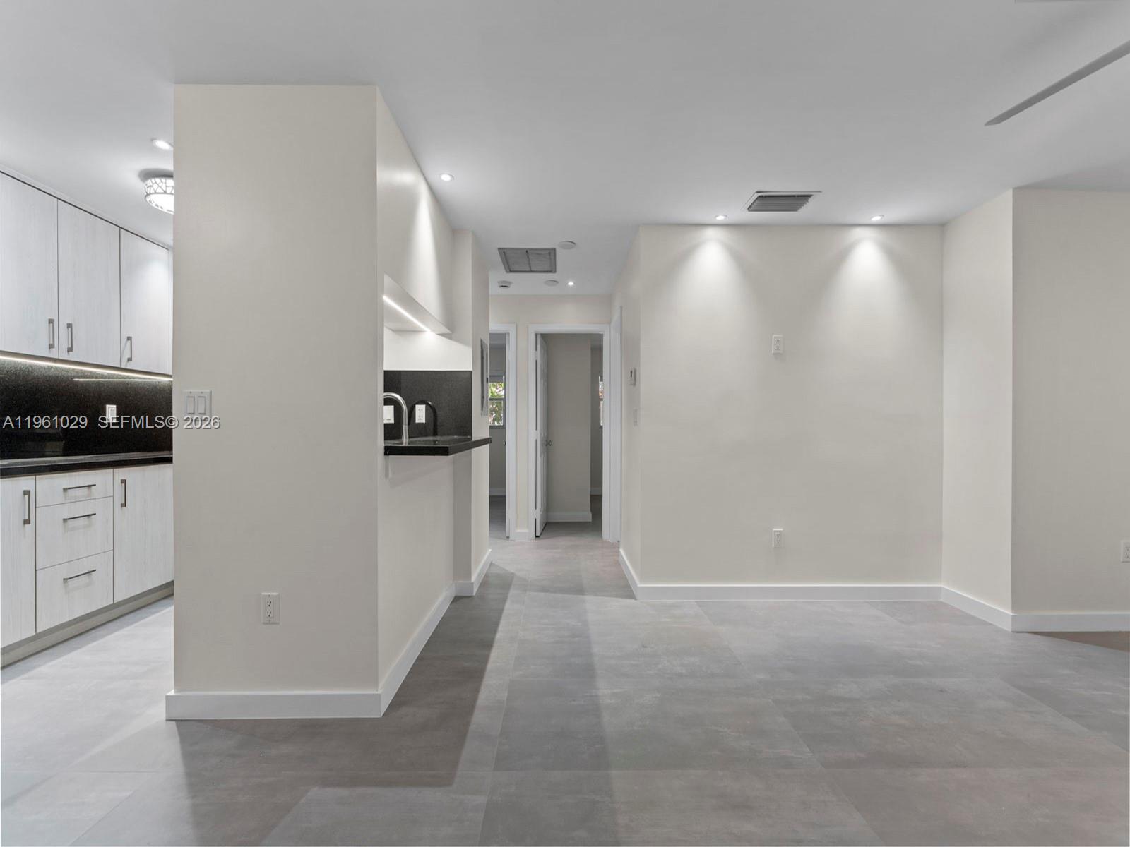 A kitchen with light wood cabinets and a breakfast bar opens into a tiled room — 15639 SW 73rd Cir Ter # 4, Miami FL 33193, MIAMI, FL