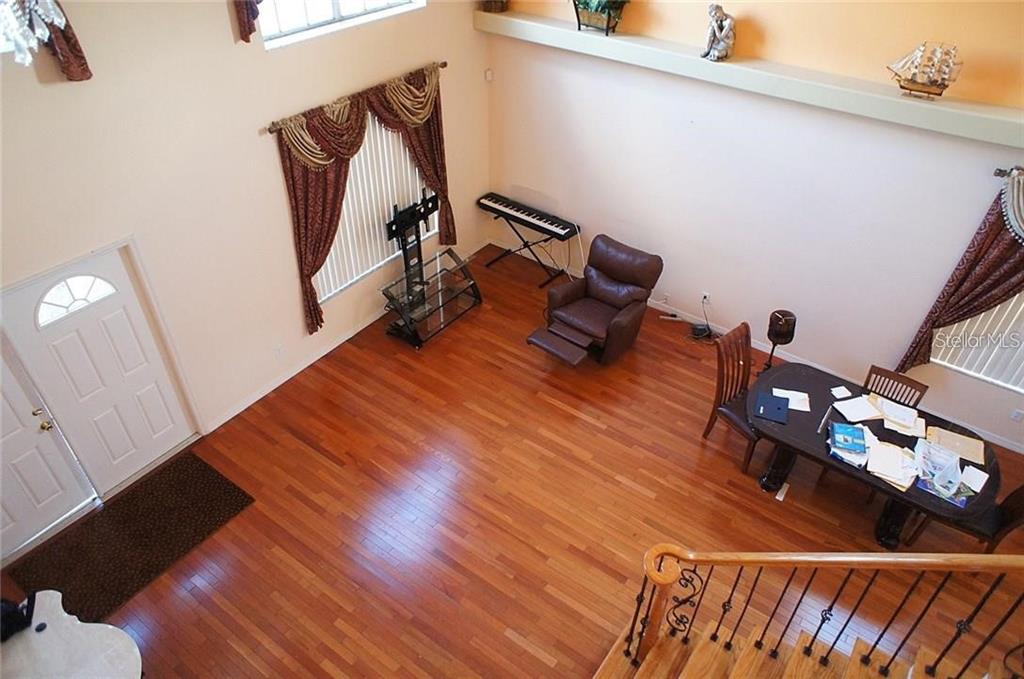 An elevated view of a living and dining area with hardwood floors and high ceilings — 5948 WINCHESTER ISLE ROAD, ORLANDO, FL