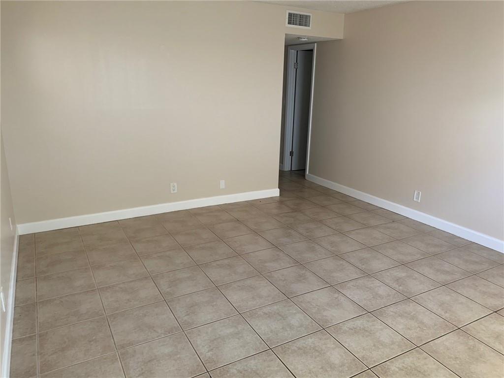 An empty room features beige walls, white baseboards, and light brown square floor tiles — 206 SW 1st Street # 4, Pompano Beach FL 33060, POMPANO BEACH, FL