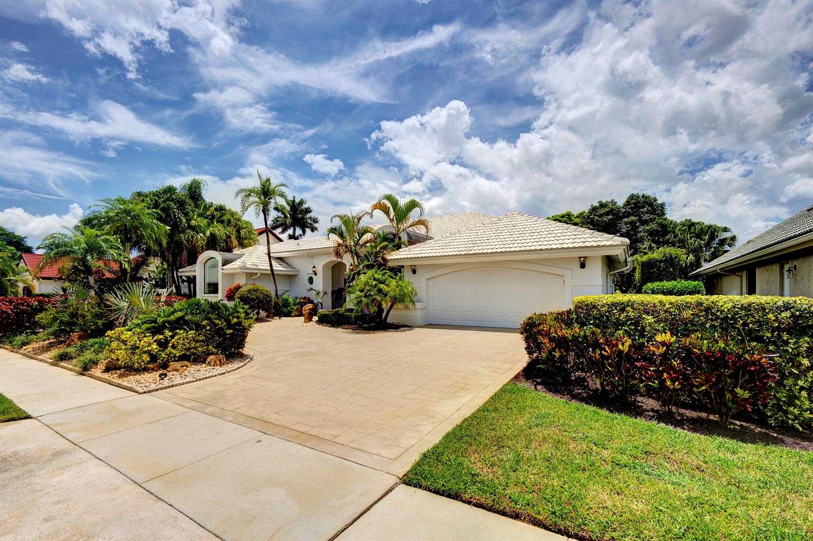 A single-story white house with a tile roof, a two-car garage, and lush landscaping — 10252 Shireoaks Lane, Boca Raton FL 33498, BOCA RATON, FL