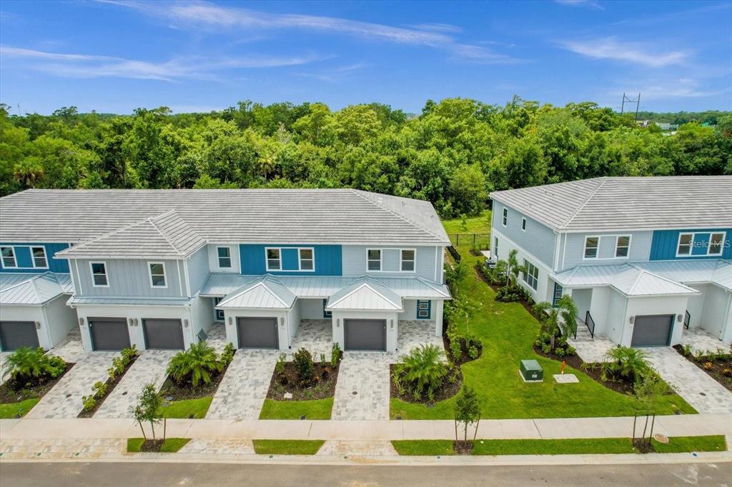 An aerial view shows a row of modern two-story townhouses with gray roofs and garages — 7818 SPECTRUM DRIVE, KISSIMMEE, FL