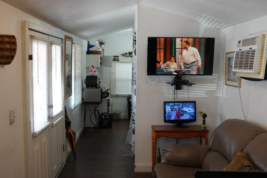 A living room features a wall-mounted television, a small monitor, and a window air conditioner — 2610 E DR MARTIN LUTHER KING JR BOULEVARD, TAMPA, FL