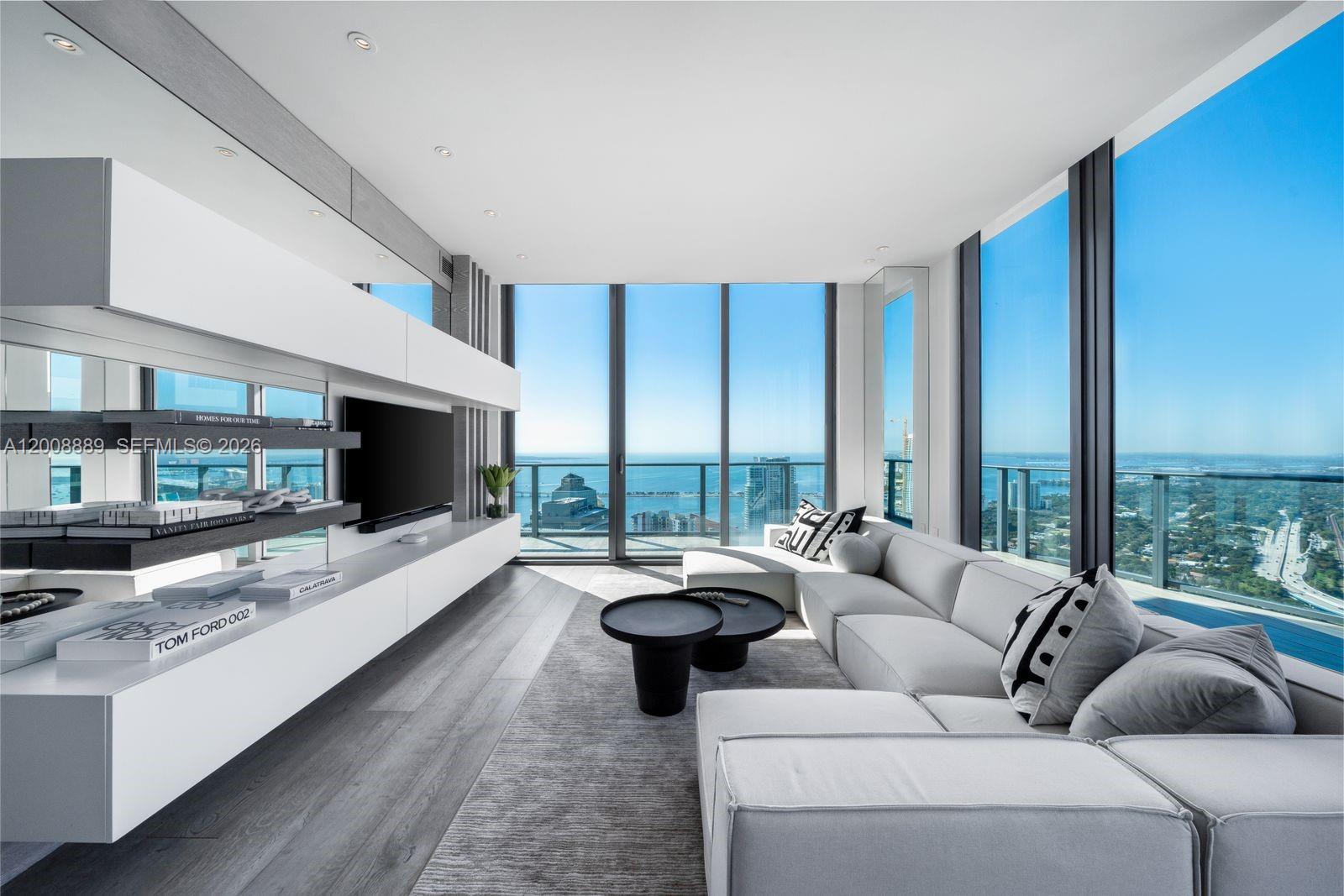 A modern living room features a white sectional sofa, media console, and floor-to-ceiling windows — 1300 S Miami Ave, Miami FL 33130, MIAMI, FL