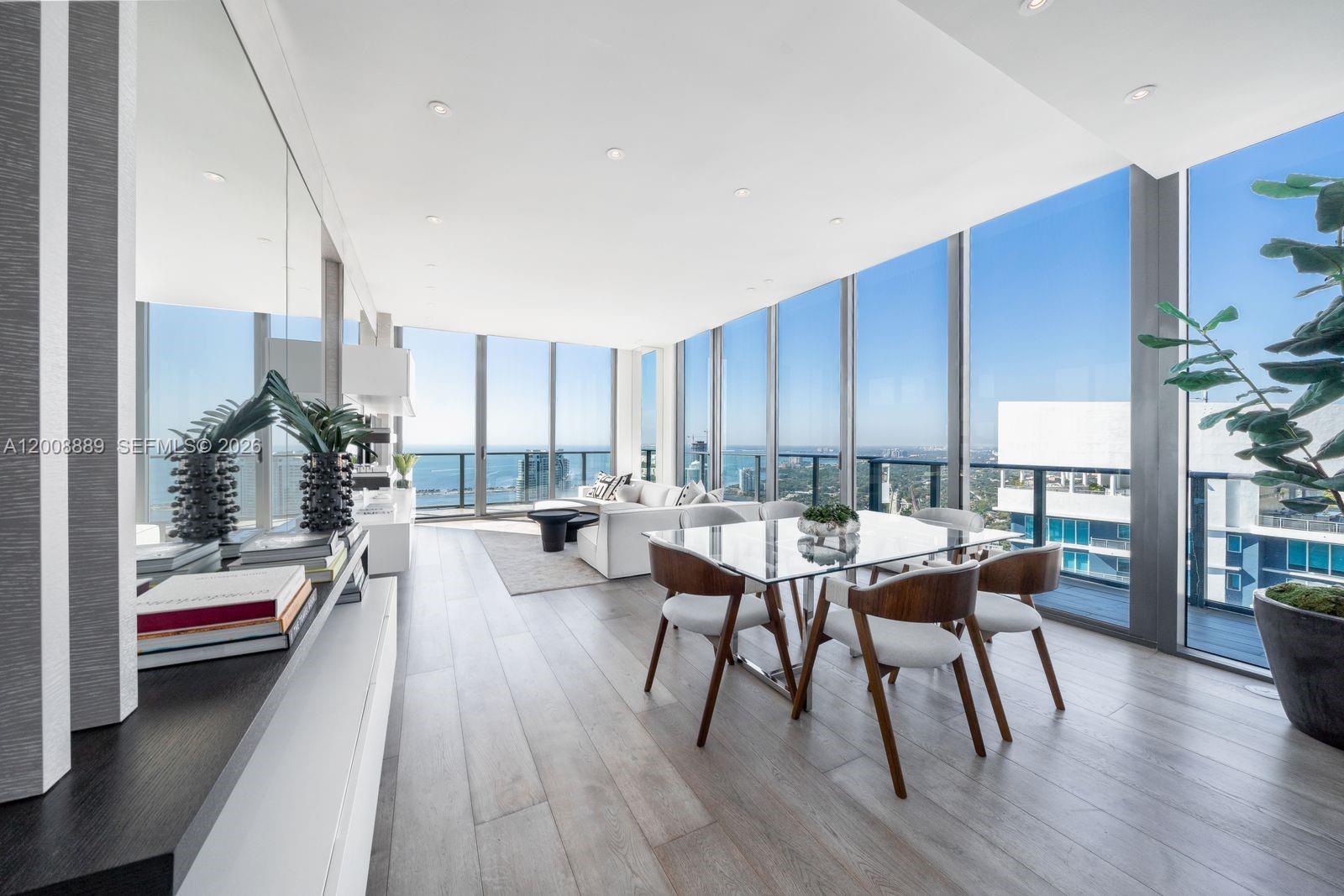 A modern dining and living area features floor-to-ceiling windows with expansive ocean and city views — 1300 S Miami Ave, Miami FL 33130, MIAMI, FL