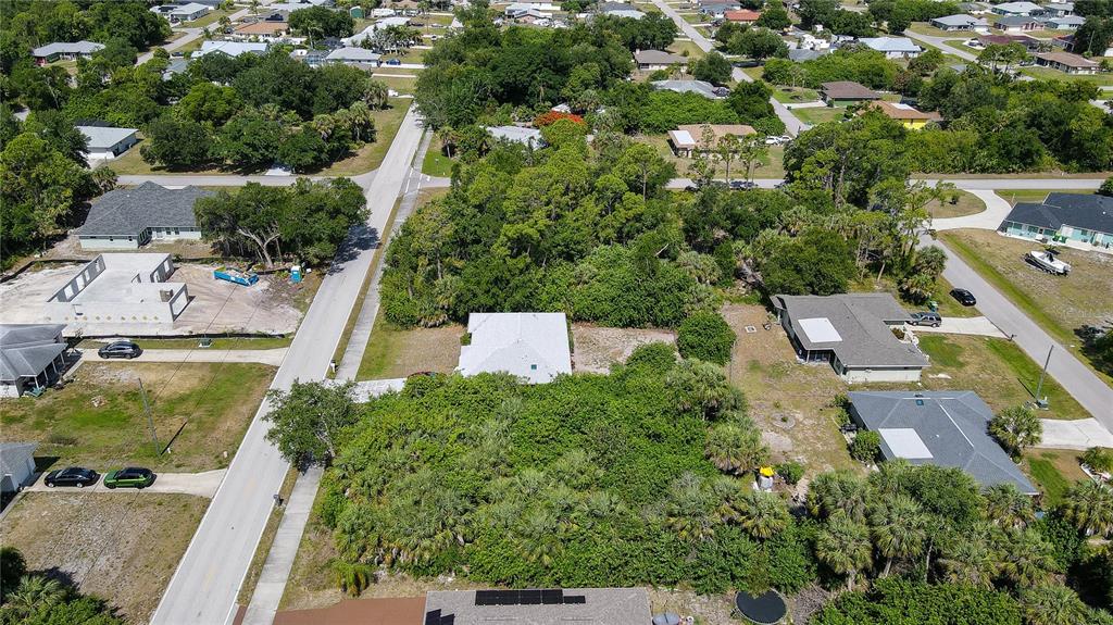 An aerial view shows a residential lot with a house surrounded by dense trees — 23164 ELMIRA BOULEVARD, PUNTA GORDA, FL