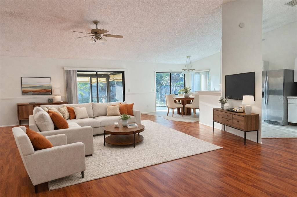 A living room with wood-look flooring, a sectional sofa, and an adjacent dining area — 1702 CYPRESS RIDGE DRIVE, ORLANDO, FL
