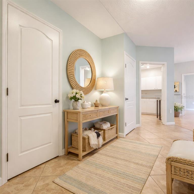 A kitchen features white cabinets, stainless steel appliances, a black stove, and light-colored tile flooring — 4865 CYPRESS WOODS DRIVE UNIT 2106, ORLANDO, FL