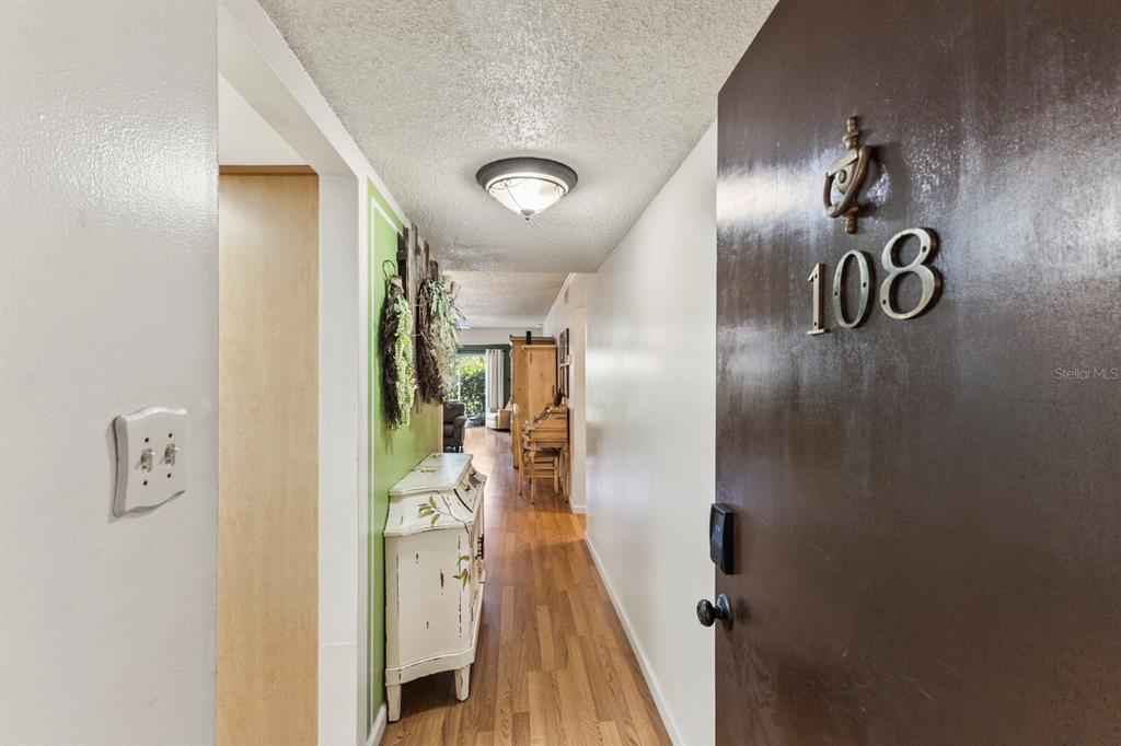 An interior view of an apartment entryway looking down a hallway toward a living area — 4015 LAKE BAYSHORE DRIVE UNIT 108, BRADENTON, FL