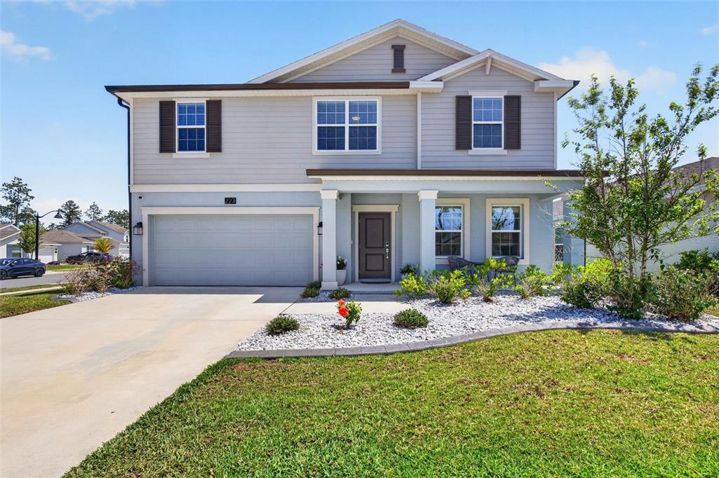 A two-story house with light blue siding, a two-car garage, and a front porch — 223 WINGED FOOT LANE, DAYTONA BEACH, FL