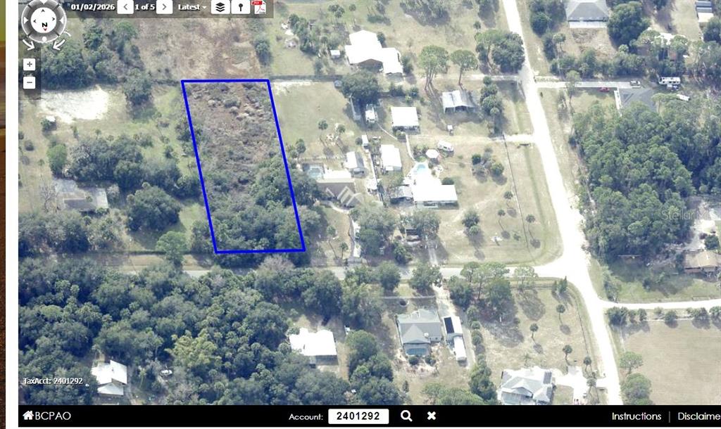 An aerial view shows a rectangular, undeveloped plot of land outlined in blue — 4095 CANAVERAL GROVES BOULEVARD, COCOA, FL
