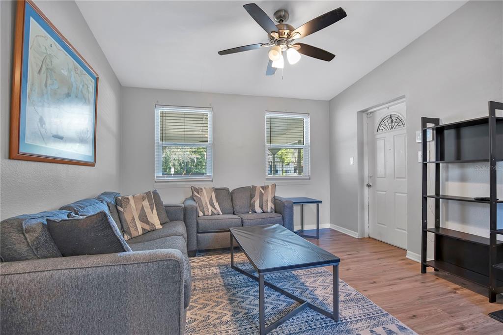 A living room features gray sofas, a coffee table, a rug, and a ceiling fan — 5450 ROSE AVENUE, ORLANDO, FL