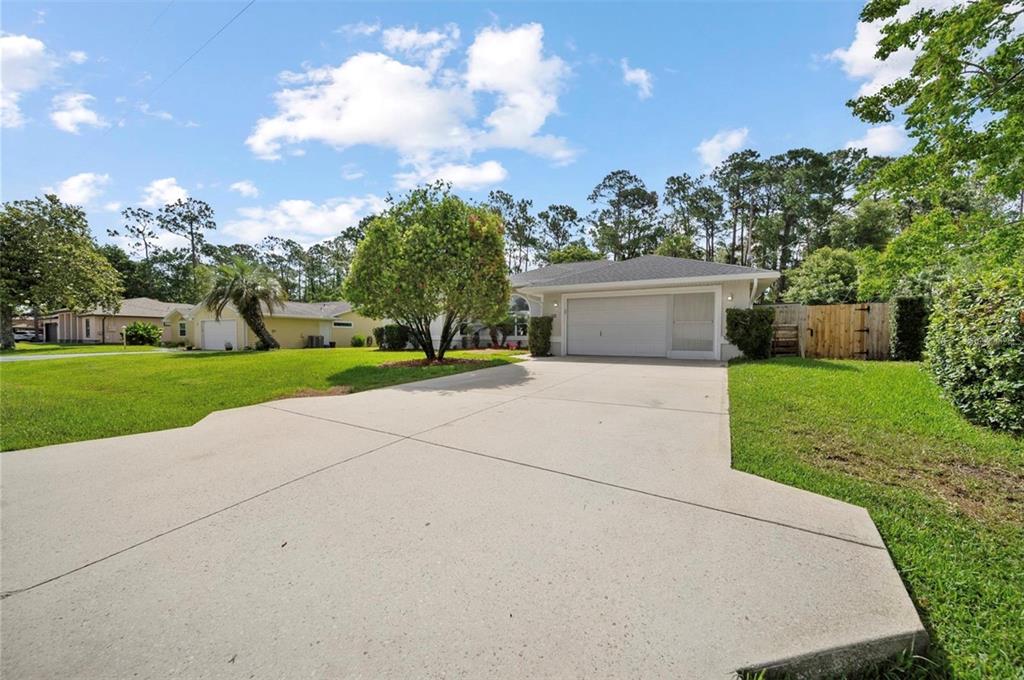 A single-story house with a concrete driveway, a two-car garage, and a grassy front yard — 10 FORTRESS PLACE, PALM COAST, FL