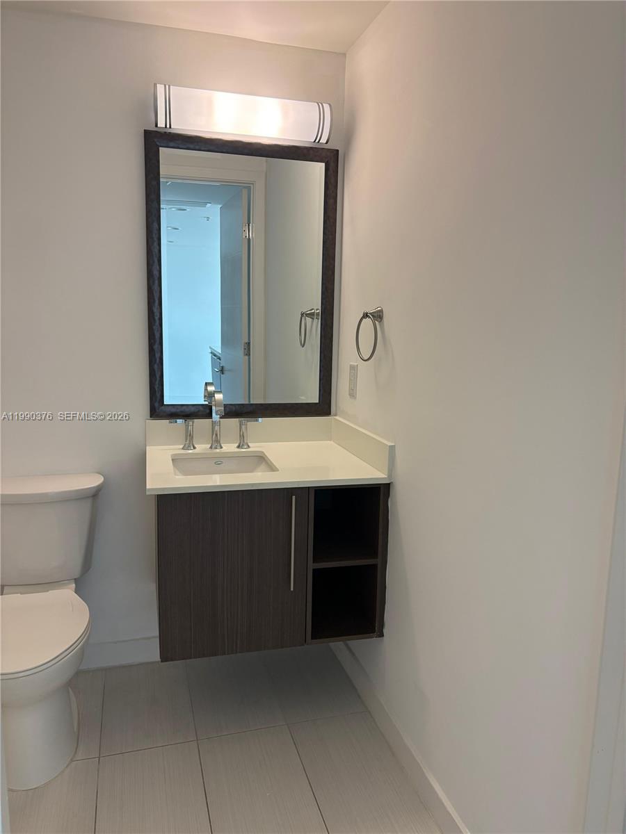 A bathroom features a floating vanity with open shelving, a mirror, and a light fixture — 7661 NW 107th Ave # 706, Doral FL 33178, DORAL, FL