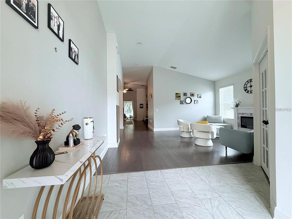 A foyer with a console table leads into a living room with hardwood floors — 6456 DOE PATH COURT, WESLEY CHAPEL, FL