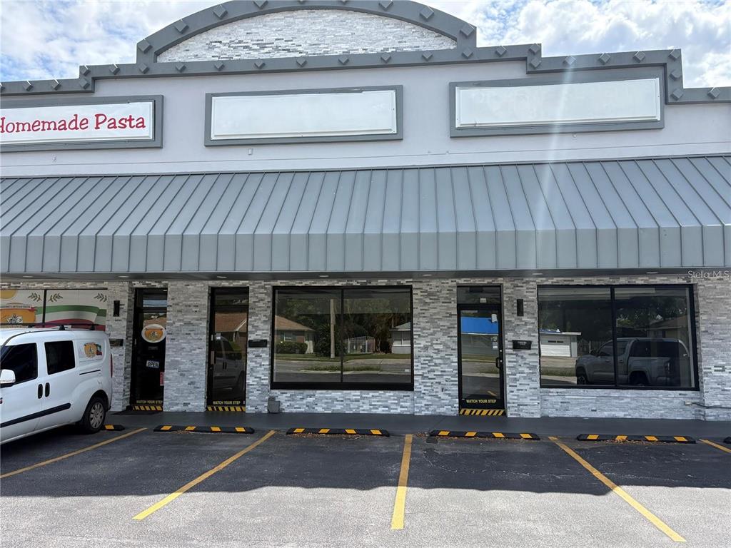 The exterior of a commercial building features a gray metal awning and stone facade — 4207 EDGEWATER DRIVE, ORLANDO, FL