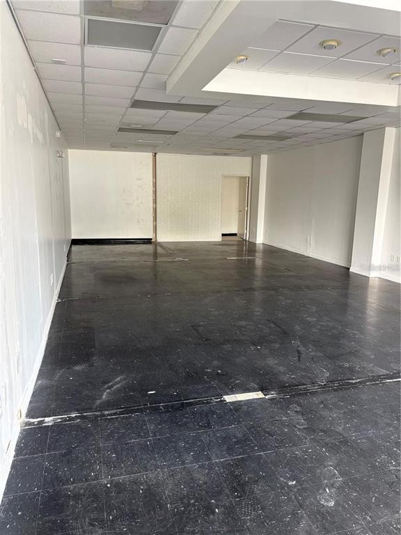 An empty commercial space with black tile flooring, white walls, and a drop ceiling — 4207 EDGEWATER DRIVE, ORLANDO, FL