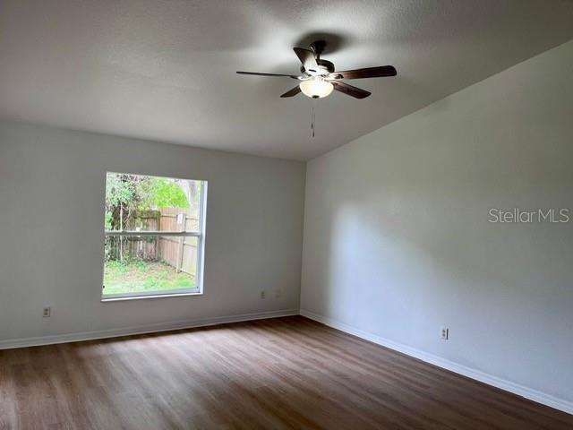 An empty room features light-colored wood-look flooring, white walls, a ceiling fan, and a window — 2115 INDIA PALM DRIVE, EDGEWATER, FL