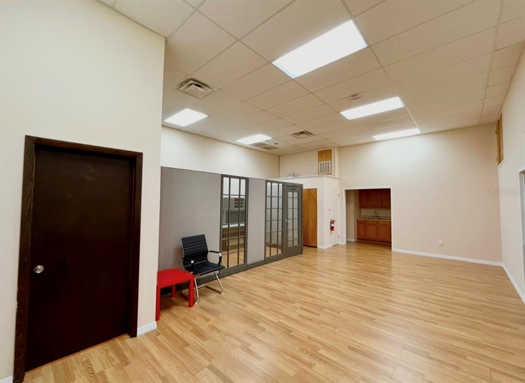 An office space with wood-look flooring, a drop ceiling, and a small kitchenette area — 8751 COMMODITY CIRCLE UNIT 4, ORLANDO, FL