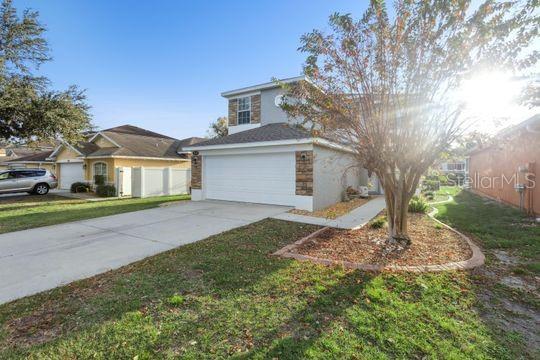 A two-story house with a two-car garage, stone accents, and a concrete driveway — 5107 NE 122ND BOULEVARD, OXFORD, FL