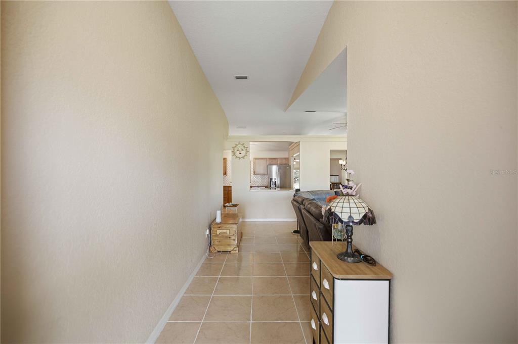 A single-story house with a two-car garage, tan stucco exterior, and a covered front entryway — 2891 SW 140TH LOOP, OCALA, FL