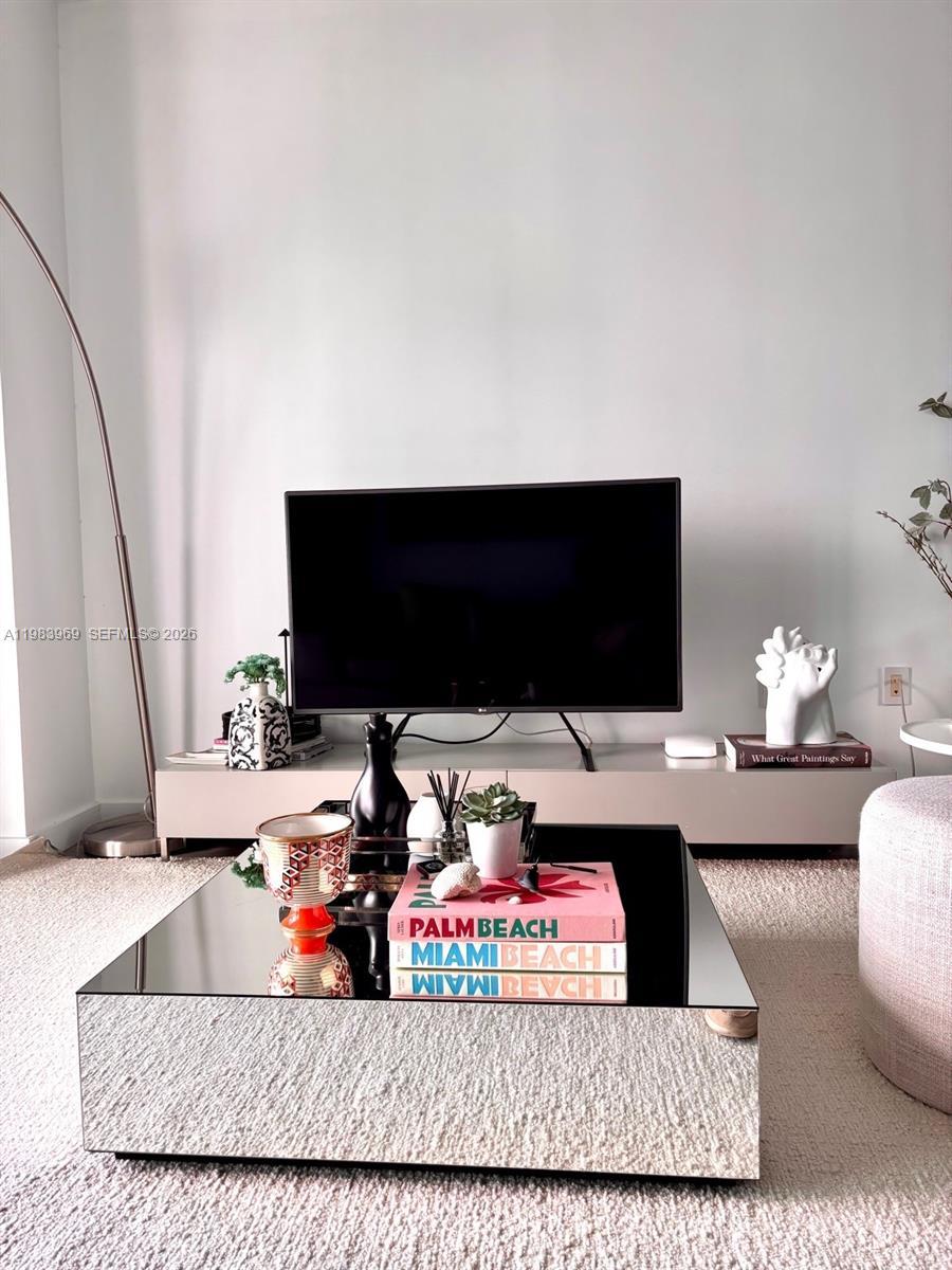 A living room features a mirrored coffee table, a television on a console, and decor — 460 NE 28th St # 2807, Miami FL 33137, MIAMI, FL