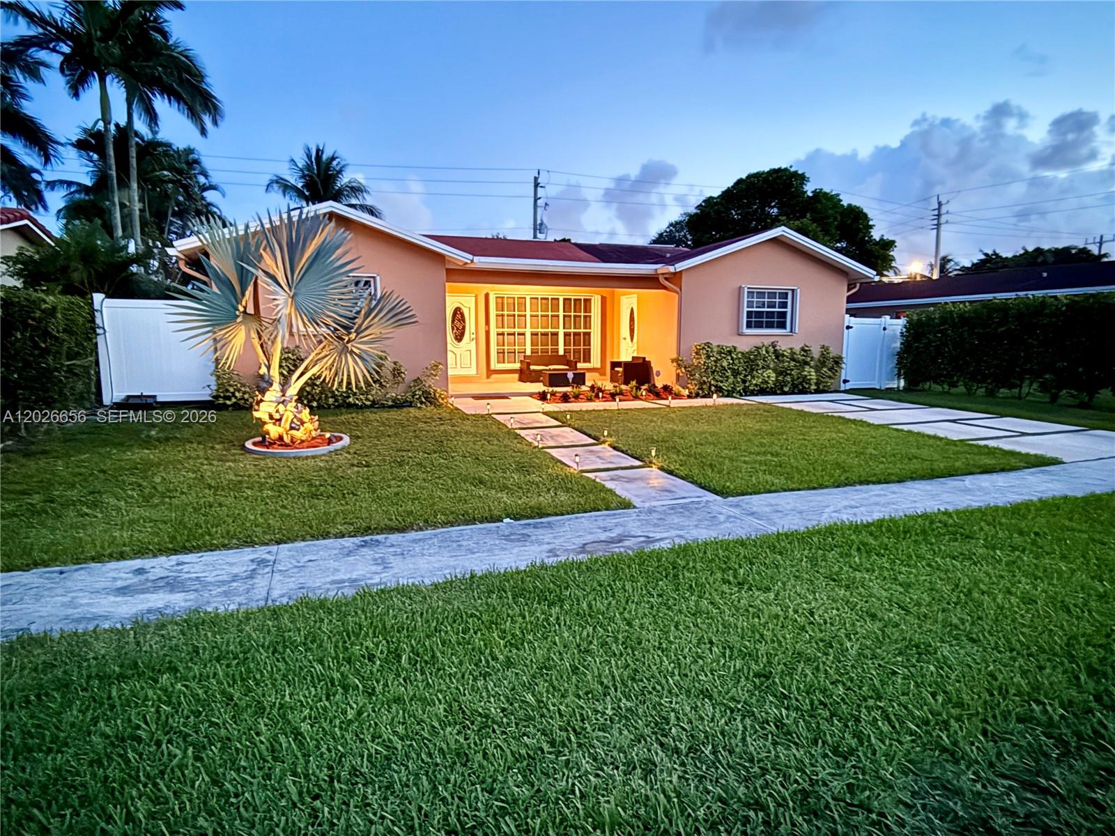 A single-story peach-colored house features a palm tree, a paved walkway, and a manicured lawn — 206 SE 3rd Pl, Dania Beach FL 33004, DANIA BEACH, FL