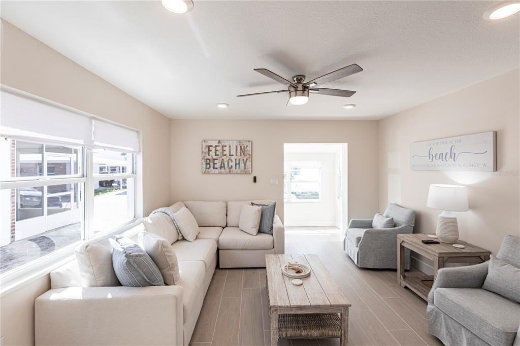 A living room features a sectional sofa, a coffee table, and light-colored tile flooring — 6020 MIDNIGHT PASS ROAD UNIT 15, SARASOTA, FL