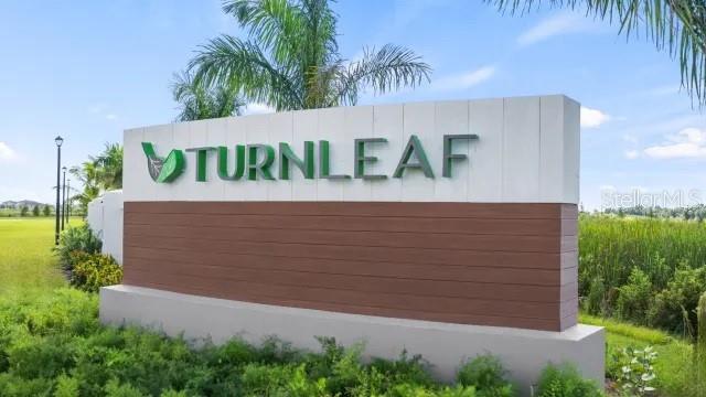 A large, modern monument sign for the Turnleaf community stands outdoors amidst green landscaping — 13038 CAMELOT LANE, PUNTA GORDA, FL