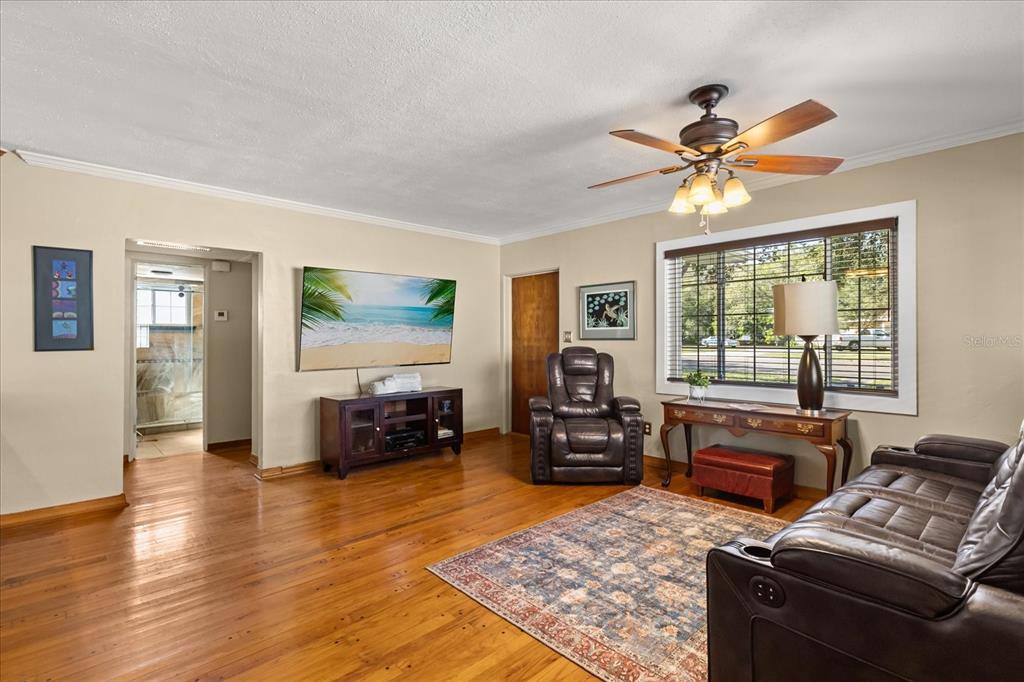 A living room features hardwood floors, a ceiling fan, a television, and leather furniture — 4237 DR MARTIN LUTHER KING JR STREET N, ST PETERSBURG, FL