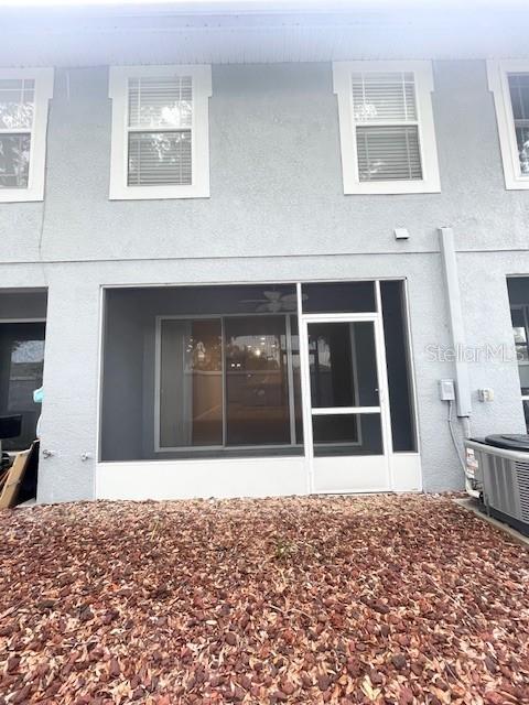 The exterior of a two-story building features a screened-in patio and a gravel yard — 6012 PARKSIDE MEADOW DRIVE, TAMPA, FL