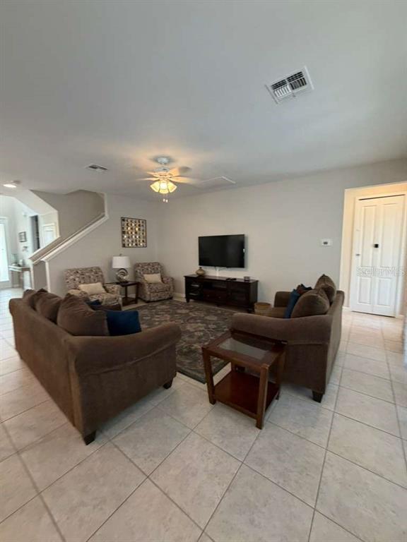 A living room features brown sofas, a television on a console, and tile flooring — 4507 MONADO DRIVE, KISSIMMEE, FL