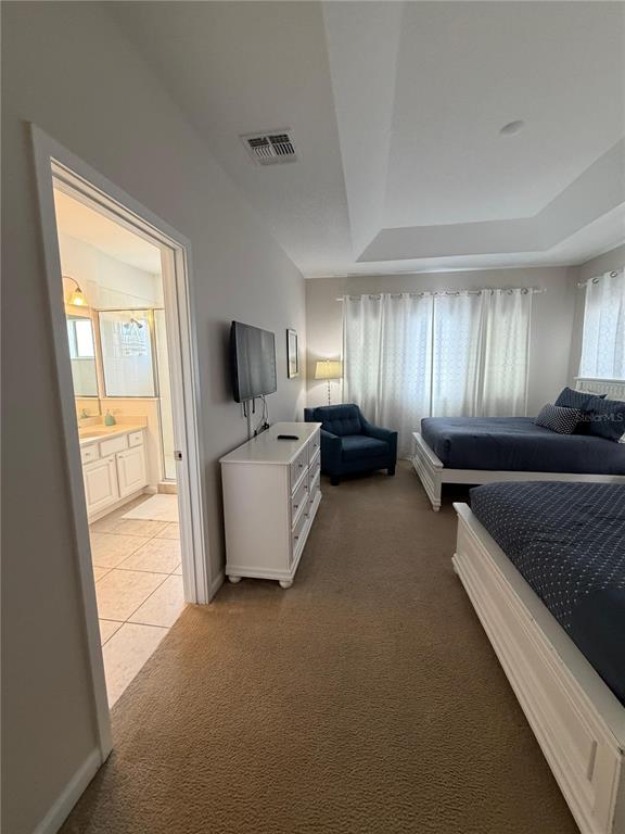 A bedroom with two beds, a dresser, a television, and an attached bathroom — 4507 MONADO DRIVE, KISSIMMEE, FL