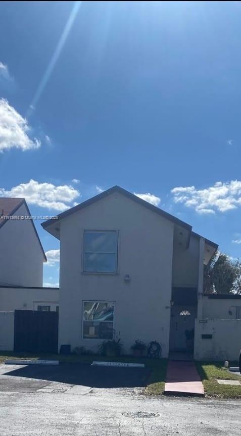 A two-story residential building with a light-colored exterior, two windows, and a front walkway — 10454 NW 5th Ter # 30, Miami FL 33172, MIAMI, FL