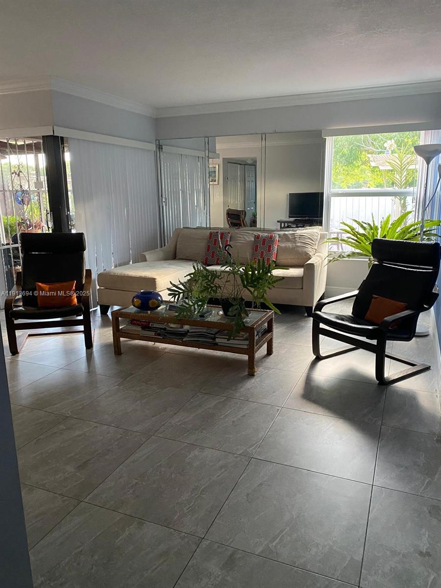 A living room features a beige sectional sofa, two black chairs, and large mirrored walls — 10454 NW 5th Ter # 30, Miami FL 33172, MIAMI, FL
