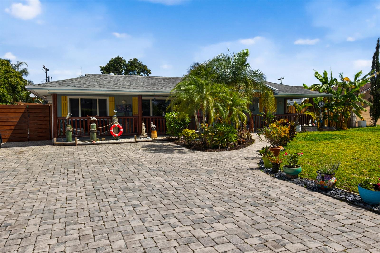 A single-story house with a paved driveway, a front porch, and tropical landscaping — 5135 Palm Ridge Boulevard, Delray Beach FL 33484, DELRAY BEACH, FL