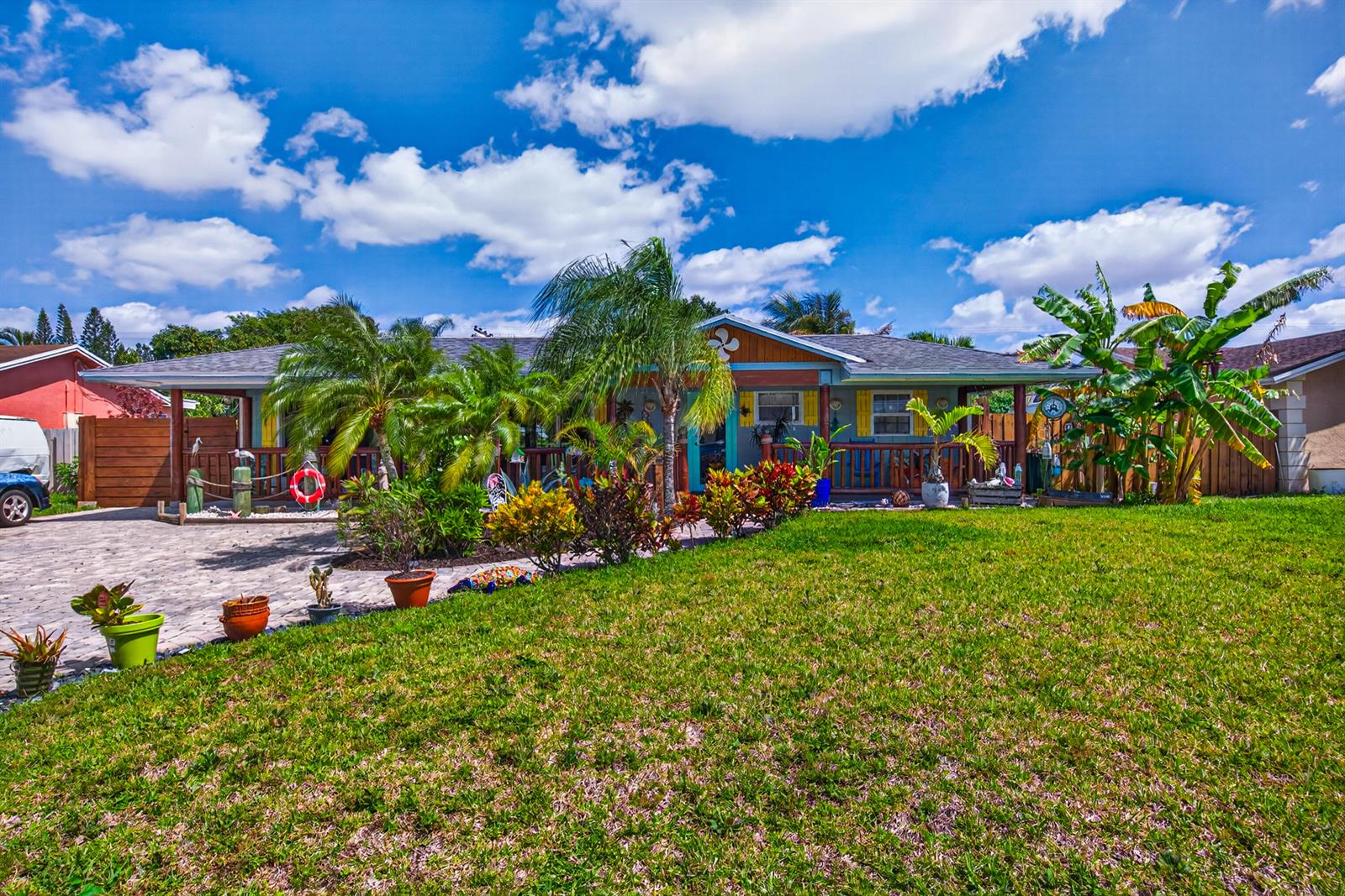 A single-story house with a covered porch, tropical landscaping, and a paved driveway — 5135 Palm Ridge Boulevard, Delray Beach FL 33484, DELRAY BEACH, FL
