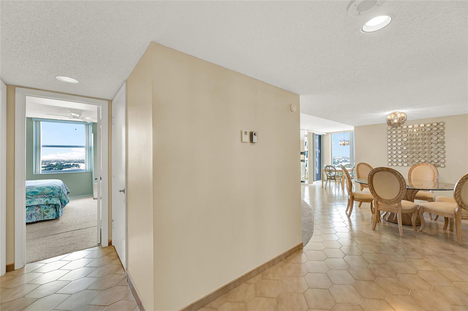 A view from a tiled hallway into a bedroom and a dining area with furniture — 1010 S Ocean Boulevard # 1509, Pompano Beach FL 33062, POMPANO BEACH, FL