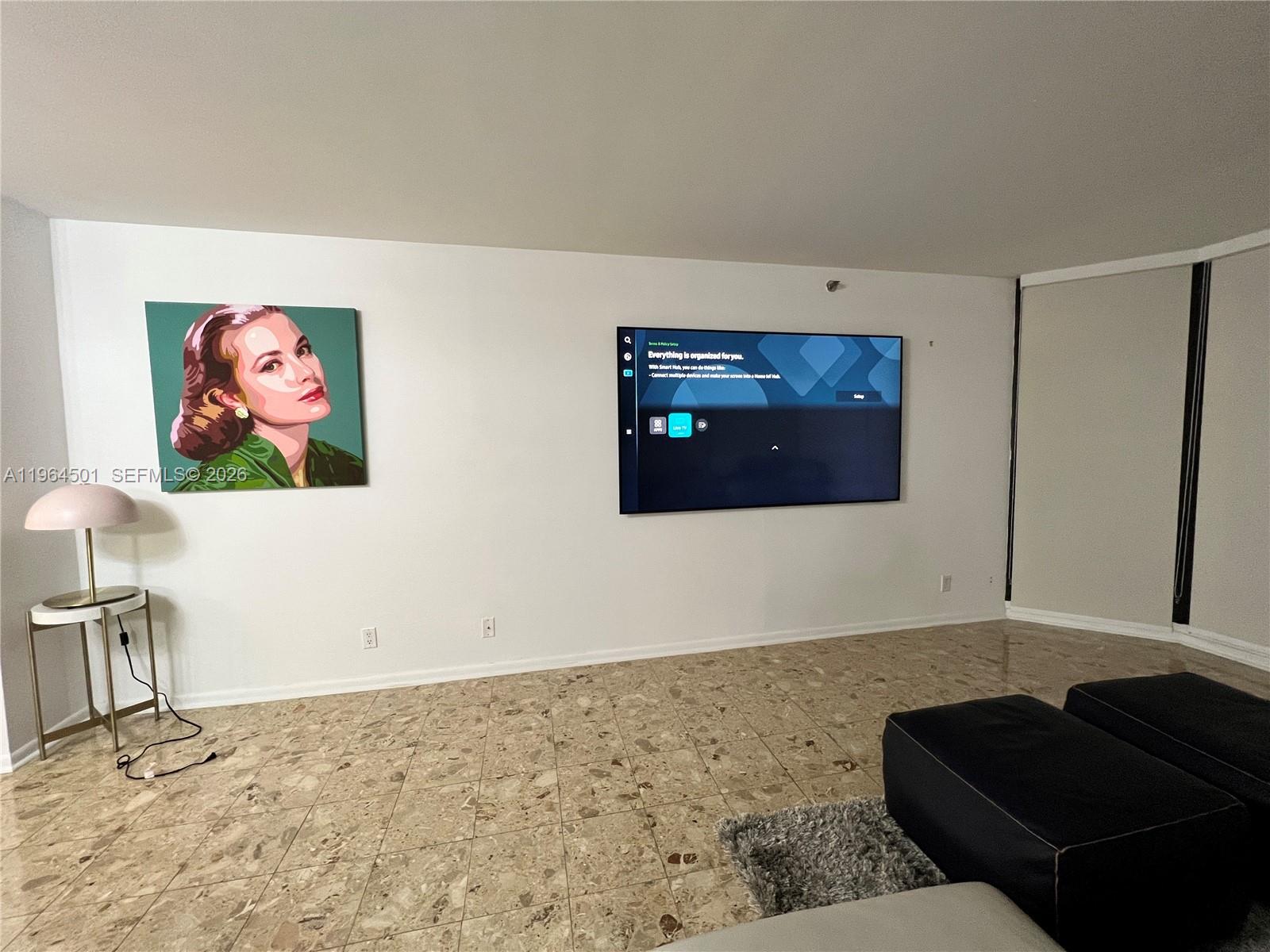 A living room features a large gray sectional sofa, a matching armchair, and marble flooring — 1717 N Bayshore Dr # 1057, Miami FL 33132, MIAMI, FL