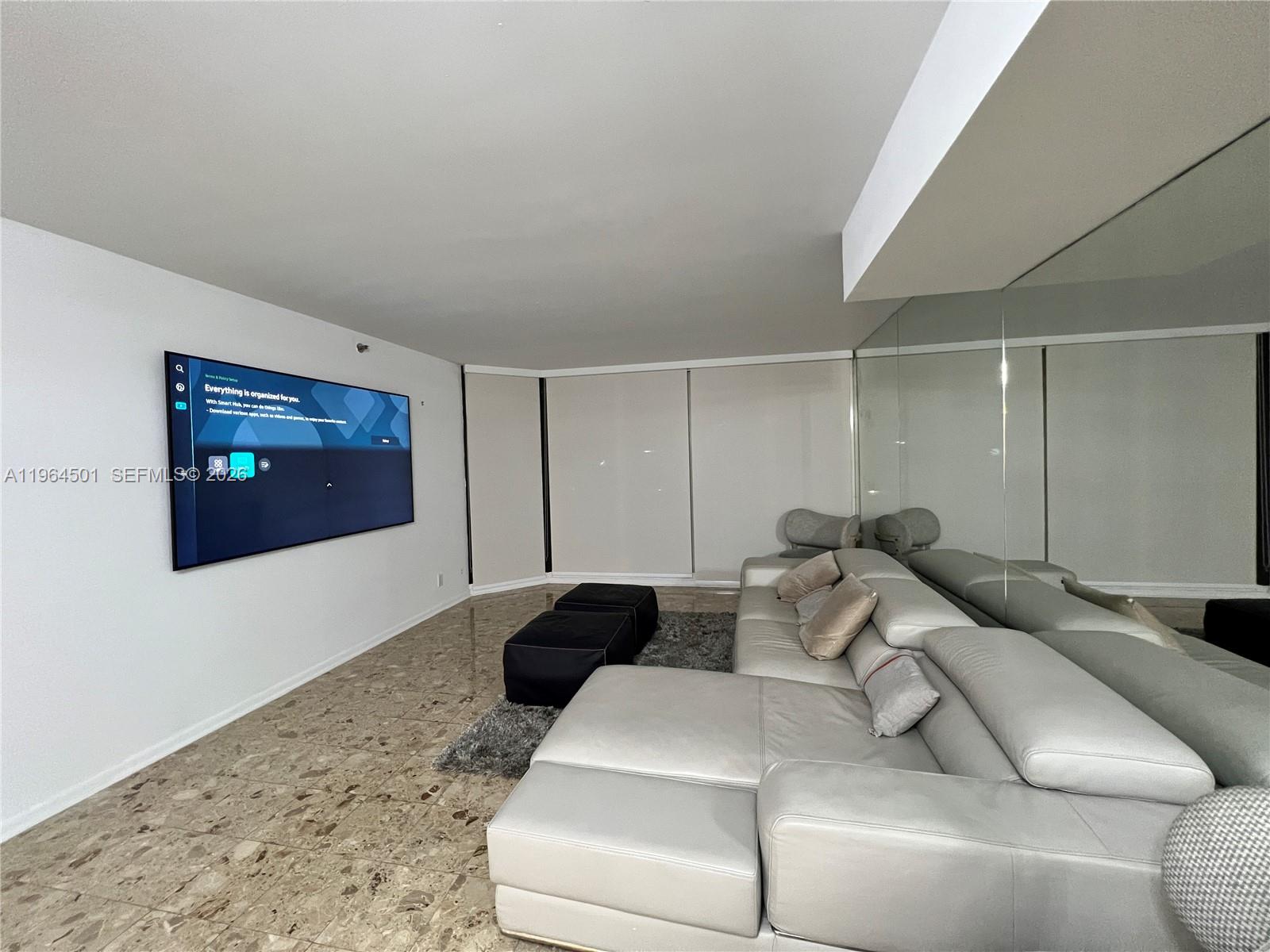 A bedroom features a bed with a light-colored headboard, two nightstands, and wood-look flooring — 1717 N Bayshore Dr # 1057, Miami FL 33132, MIAMI, FL