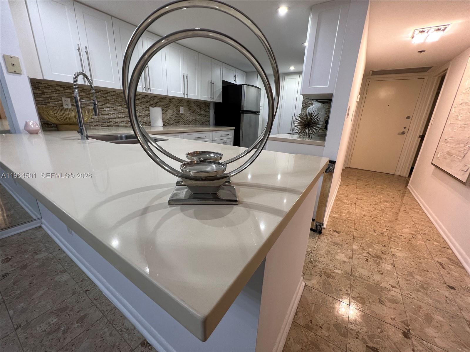 A bathroom features a white vanity with a beige countertop, a toilet, and tile flooring — 1717 N Bayshore Dr # 1057, Miami FL 33132, MIAMI, FL