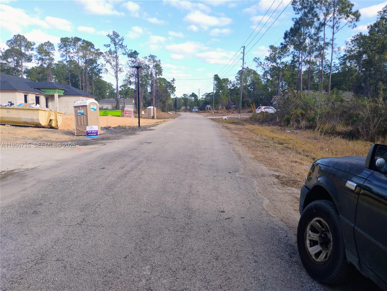 A paved road leads past a construction site with a dumpster and portable toilet — 4213 Gerona, Avon Park FL 33872, AVON PARK, FL